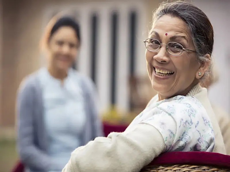 Woman smiling while seated, symbolizing comfort and support during individual therapy.